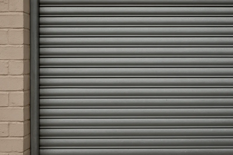 A close view of metal shutter slats running in a side channel — bushfire shutters, Blue Mountains. Illustrative example.